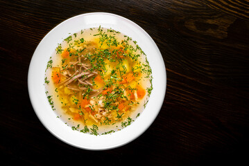 Bowl of meat and vegetable soup on a table