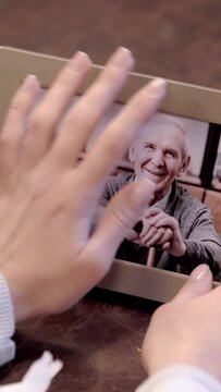 vertical video of cropped woman holding photo of senior man