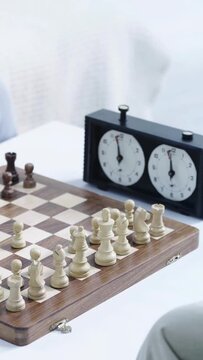 vertical video of cropped senior men playing chess and pressing button on chess clock