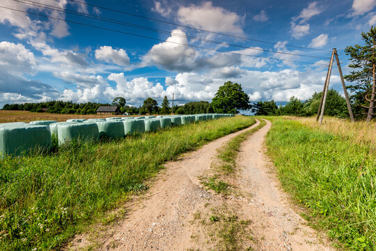 Countryside road among harvested cereals, agricultural landscape
