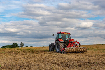Obraz premium Tractor in european countryside. Harvest season.