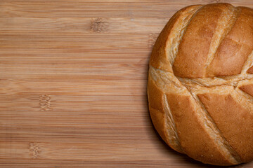 Freshly baked bread on wooden tops background, top view with space for clear text.