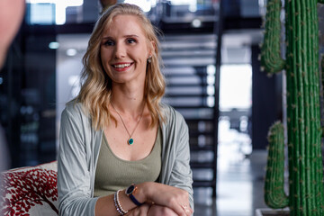 Smiling businesswoman listening to colleague in office