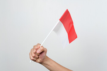 Hand holding red and white Indonesia flag attribute, independence day concept