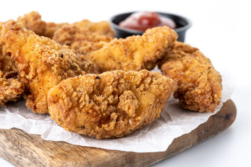 Crispy Kentucky fried chicken on cutting board isolated on white background	