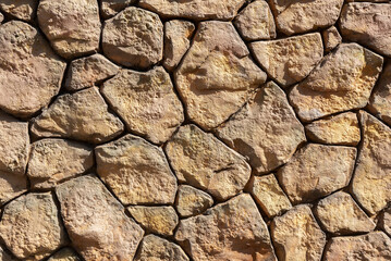 Closeup view of surface of rough stone wall.