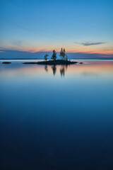 Obraz premium Small island in dusk surrounded by water at night