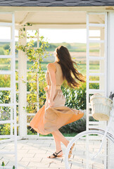 A beautiful brunette is circling in a gazebo on the shore of a lake.