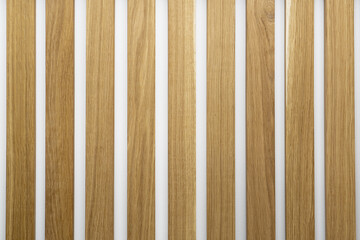 Wooden slats on white wall. Natural oak wood lath textured background.