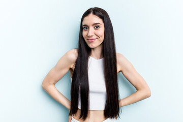 Young caucasian woman isolated on blue background happy, smiling and cheerful.