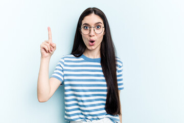 Young caucasian woman isolated on blue background having an idea, inspiration concept.