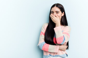 Young caucasian woman isolated on blue background laughing happy, carefree, natural emotion.