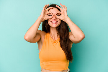 Young caucasian woman isolated on blue background excited keeping ok gesture on eye.