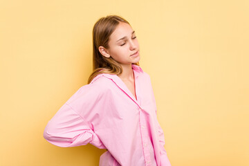 Young caucasian girl isolated on yellow background suffering a back pain.