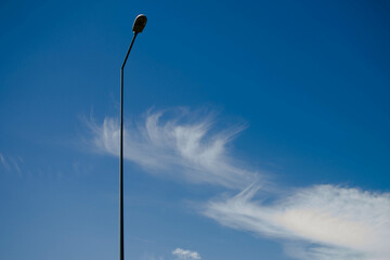 street lamp on the background of the blue sky with white clouds