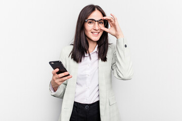 Young business caucasian woman holding mobile phone isolated on white background excited keeping ok gesture on eye.