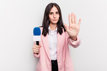 Young TV presenter caucasian woman isolated on white background standing with outstretched hand showing stop sign, preventing you.