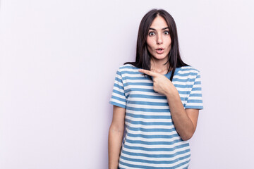 Obraz premium Young caucasian woman isolated on pink background pointing to the side