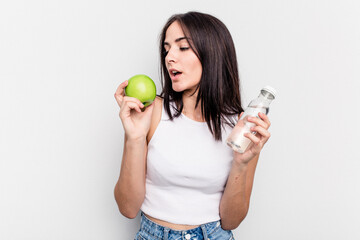 Young caucasian woman holding apple and bottle of water isolated on white background
