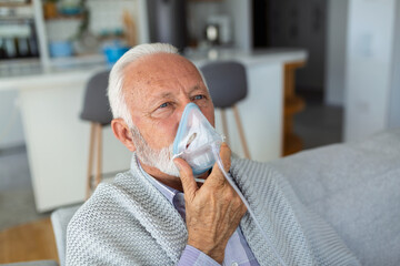 Sick elderly man making inhalation, medicine is the best medicine. Ill senior man wearing an oxygen...