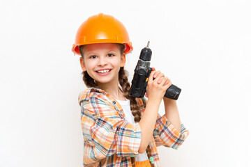 A little girl with an electric screwdriver in a protective orange construction helmet smiles broadly on a white isolated background. The concept of renovation in the room of a teenage girl.