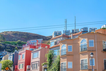 Rowhouses and apartment buildings near the mountain with two cell towers on top in San Francisco, CA