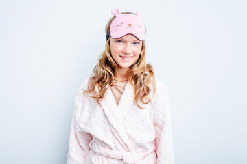 Caucasian teen girl wearing a pajama isolated on blue background happy, smiling and cheerful.