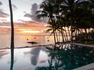 Sunrise with reflection at at hotel pool in Belle Mare, Mauritius