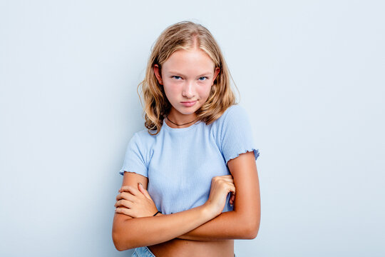 Caucasian teen girl isolated on blue background frowning face in displeasure, keeps arms folded.