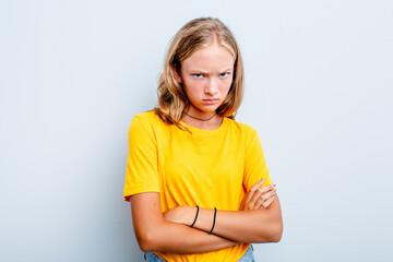 Caucasian teen girl isolated on blue background frowning face in displeasure, keeps arms folded.