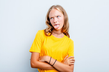 Caucasian teen girl isolated on blue background funny and friendly sticking out tongue.