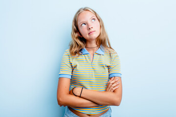 Caucasian teen girl isolated on blue background dreaming of achieving goals and purposes