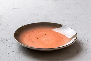 Perspective view of empty red plate on cement background. Empty space for your design