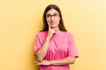 Young caucasian woman isolated on yellow background contemplating, planning a strategy, thinking about the way of a business.