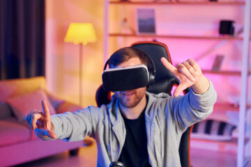 Epic adventure. Portrait of gamer in VR glasses that playing game and streaming it online