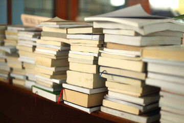 Stacks of books in the school library. Many books piles. Education learning concept.