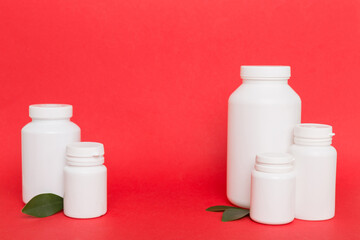 supplement pills with medicine bottle health care and medical top view. Vitamin tablets. Top view mockup bottle for pills and vitamins with green leaves, natural organic bio supplement, copy space