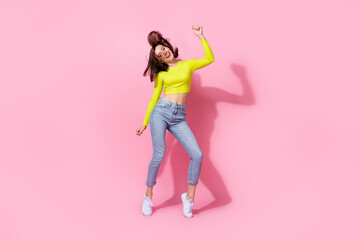 Fototapeta na wymiar Full body photo of adorable slim sweet girl satisfied new trendy outfit good mood raise arm enjoy dance isolated on pink color background