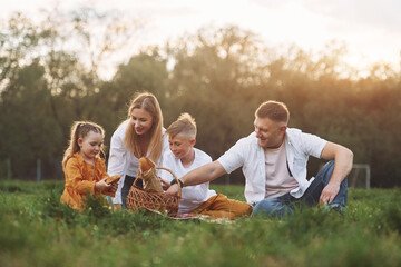 Sitting on the green grass. Family have weekend outdoors at summertime together