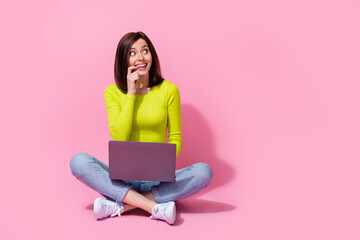 Photo of cunning positive playful lady sit look up blank space use gadget device have plan idea hmm...