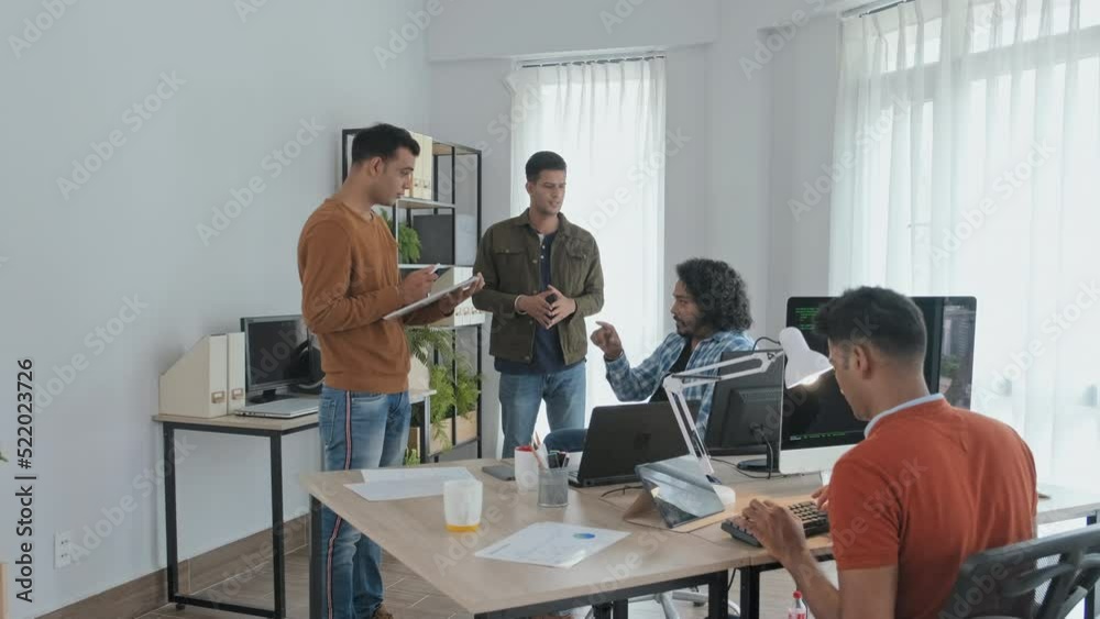 Wall mural slowmo of team of indian programmers brainstorming ideas while working together in office