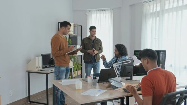 Slowmo of team of Indian programmers brainstorming ideas while working together in office