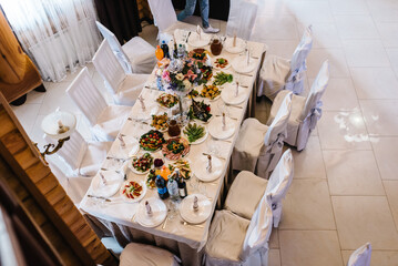 Festive table at the banquet hall. Serving guests, setting table. Plates, silverware cutlery, glass, napkin. Wedding table decoration. Top view.