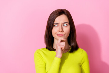 Photo of pretty minded doubtful lady look interested empty space hand touch chin isolated on pink...