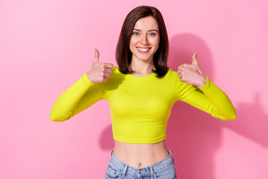 Photo of pretty cheerful girl hands fingers demonstrate thumb up isolated on pink color background