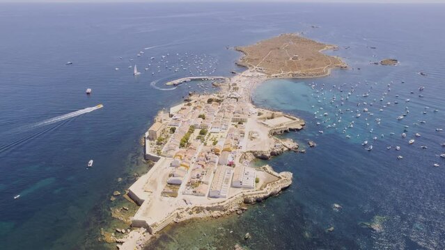 Aerial view of Tabarca island with boats at anchor. Mediterranean Sea. Popular travel destinations at summer. Spain. Cinematic 4K