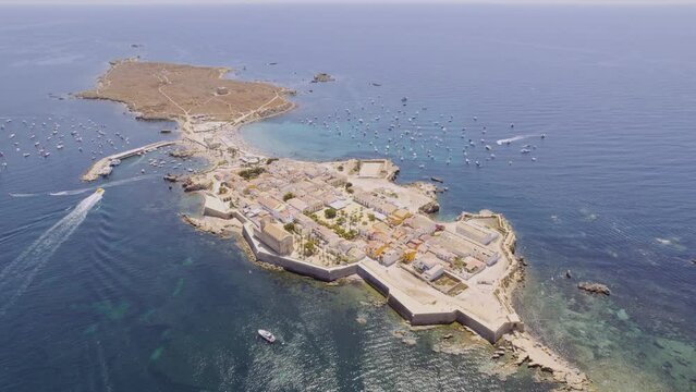 Aerial view of Tabarca island with boats at anchor. Mediterranean Sea. Popular travel destinations at summer. Spain. Cinematic 4K
