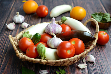 Composition with raw vegetables in a wicker basket on a wooden background. harvest