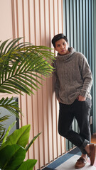 LGBT tomboy Asian woman in autumn sweater house interior