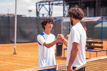 Portrait of handshake of two padel tennis players - Padel players embracing after win a padel match